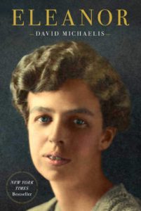 The Cover of the 2020 Biography of Eleanor Roosevelt, Eleanor, by Davi Michaelis. The cover states the title and author's name above a colorized photograph of a young Eleanor Roosevelt's face. In the bottom left corner a circle of text says that the book is a New York Times Bestseller