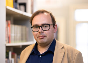 Profile picture of Michael Becker against a backdrop of library books